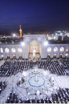 Muslims praying at the main courtyard in Imam Reza`s Holy Shrine in Mashhad - Iran
