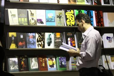 Homem em um estande, na feira internacional do livro em Teerã, capital do Irã