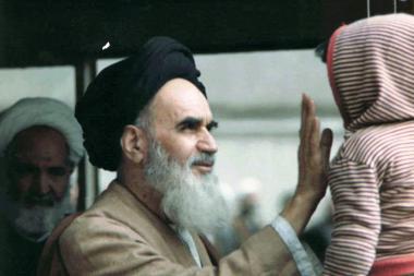 Imam Khomeini brincando com uma criança