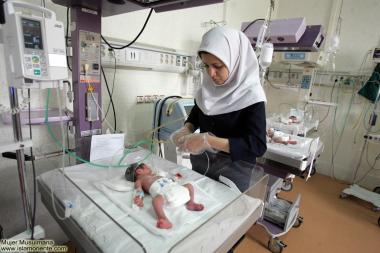 Medica muçulmana cuidando de crianças recém nascidas  