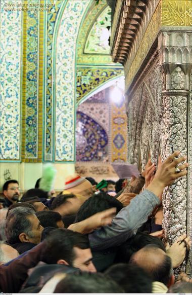 Menschen greifen nach dem heiligen Grab Imam Reza&#039;s in der heiligen Stadt Maschhad - Iran - Die Stadt Maschhad in Iran - Imam Reza - Foto