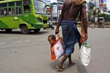 Um homem hindu carregando seu bebê 